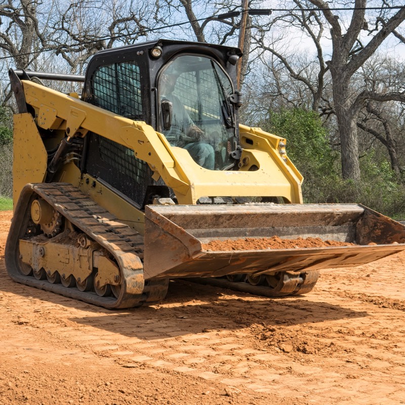 Skid steer hauling sand for backyard renovation